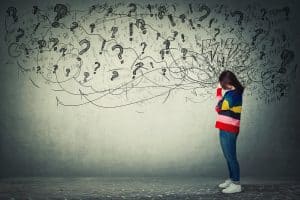 A woman stands with exclamation points and question marks surrounding her. This could symbolize the struggle with ADHD symptoms in Asheville, NC. Contact an Asheville mental health therapist today to learn how Asheville therapists can help you.
